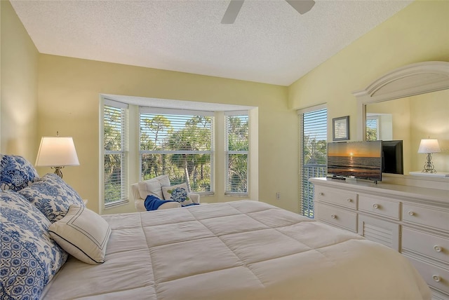 bedroom with a textured ceiling, multiple windows, lofted ceiling, and ceiling fan