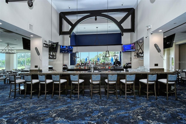 bar with beamed ceiling, a towering ceiling, and dark stone counters