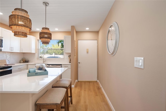 kitchen featuring decorative light fixtures, white cabinetry, a kitchen island, and tasteful backsplash