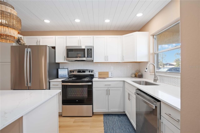 kitchen featuring sink, white cabinets, appliances with stainless steel finishes, and light hardwood / wood-style flooring