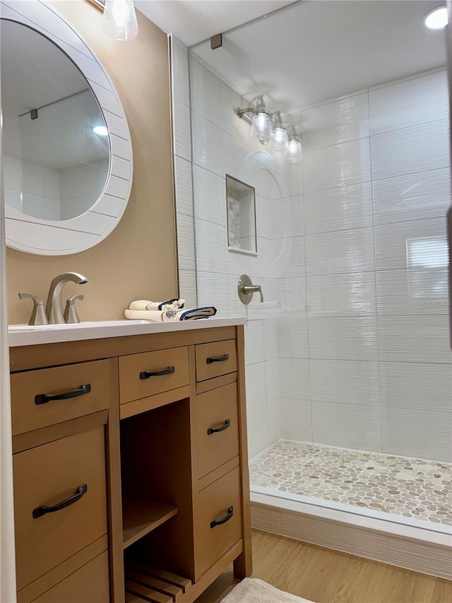 bathroom featuring vanity, hardwood / wood-style flooring, and a tile shower