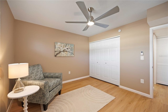 sitting room with ceiling fan and wood-type flooring