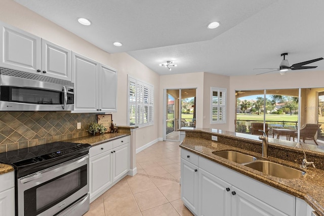 kitchen with dark stone countertops, sink, white cabinetry, and stainless steel appliances