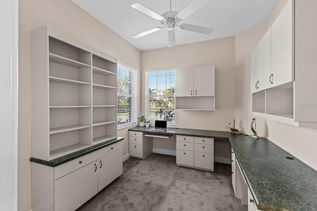 office area with ceiling fan, light colored carpet, and built in desk