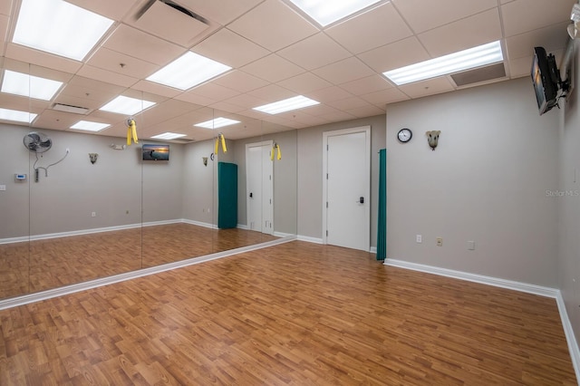 unfurnished room with a paneled ceiling and hardwood / wood-style flooring