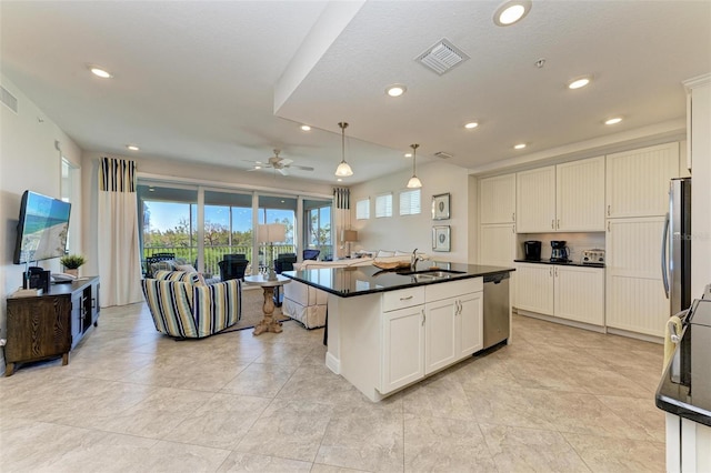 kitchen with white cabinets, sink, an island with sink, and hanging light fixtures