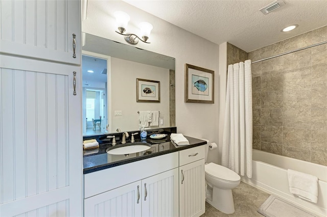 full bathroom featuring a textured ceiling, vanity, shower / tub combo with curtain, tile patterned flooring, and toilet