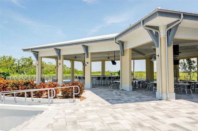 surrounding community featuring a gazebo, a patio area, and a bar