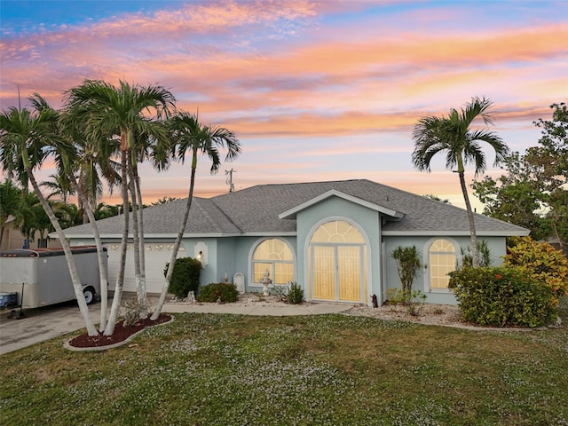 single story home with a garage and a yard