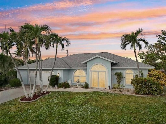 ranch-style house featuring a yard and a garage