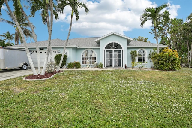 ranch-style home with a garage and a front lawn