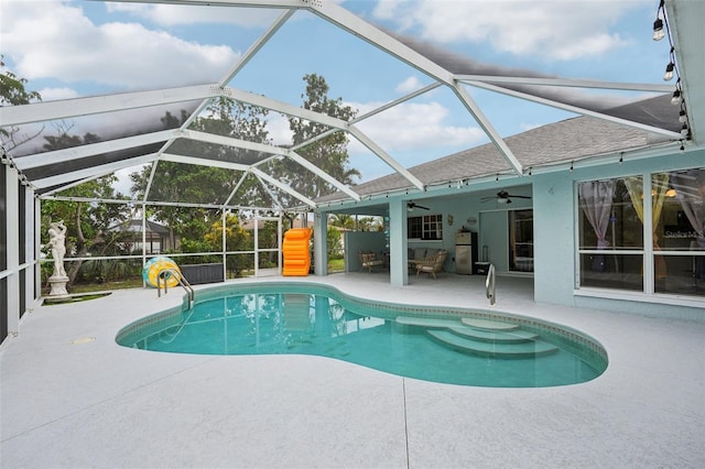 view of swimming pool featuring a patio area, ceiling fan, and glass enclosure