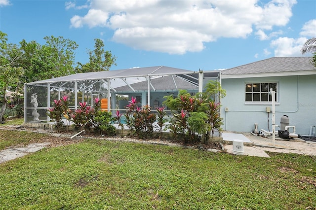 back of property featuring a lanai and a yard