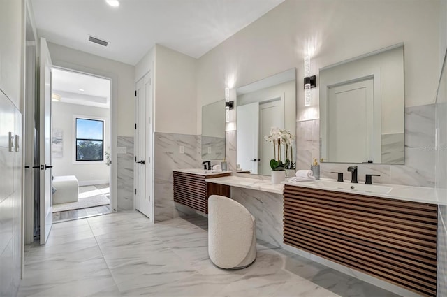 bathroom with vanity and tile walls