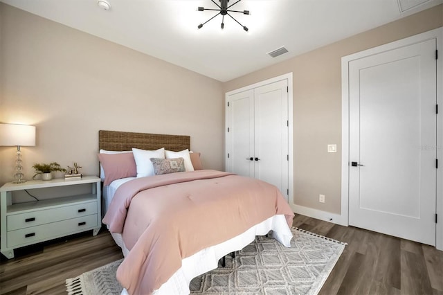 bedroom with dark hardwood / wood-style flooring and a closet