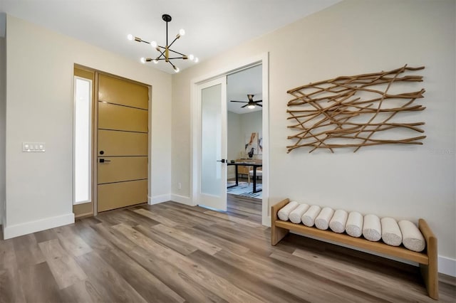 entrance foyer featuring hardwood / wood-style floors and ceiling fan with notable chandelier