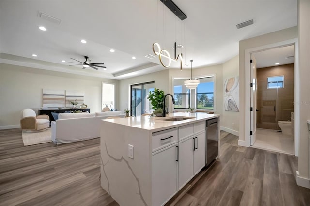 kitchen featuring a kitchen island with sink, sink, decorative light fixtures, dark hardwood / wood-style flooring, and white cabinetry