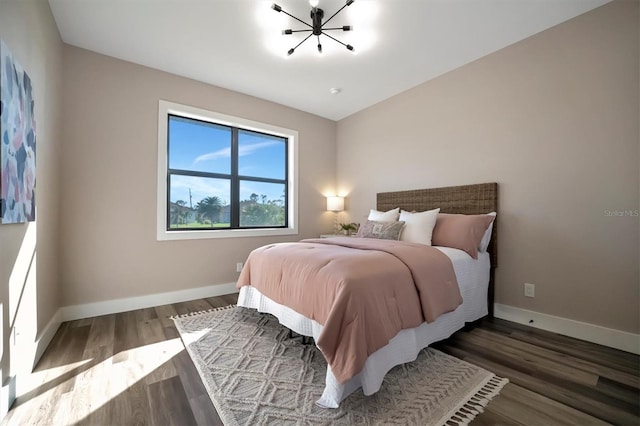 bedroom featuring dark hardwood / wood-style flooring and an inviting chandelier