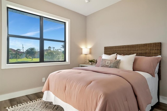 bedroom featuring dark hardwood / wood-style flooring and multiple windows