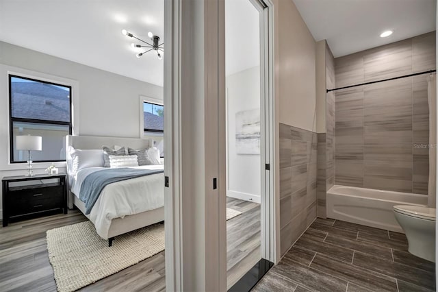 bedroom with tile walls and hardwood / wood-style flooring