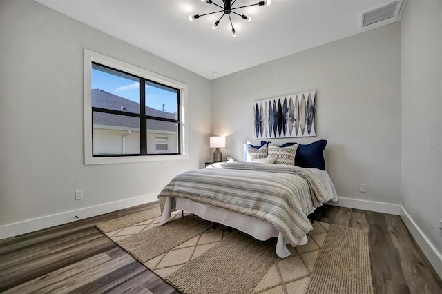 bedroom with a notable chandelier, dark wood-type flooring, and vaulted ceiling