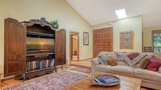 living room with lofted ceiling with skylight and hardwood / wood-style flooring