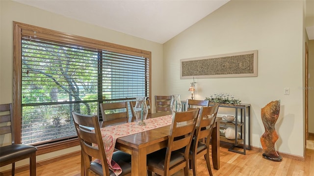 dining area featuring a healthy amount of sunlight, vaulted ceiling, and light hardwood / wood-style floors