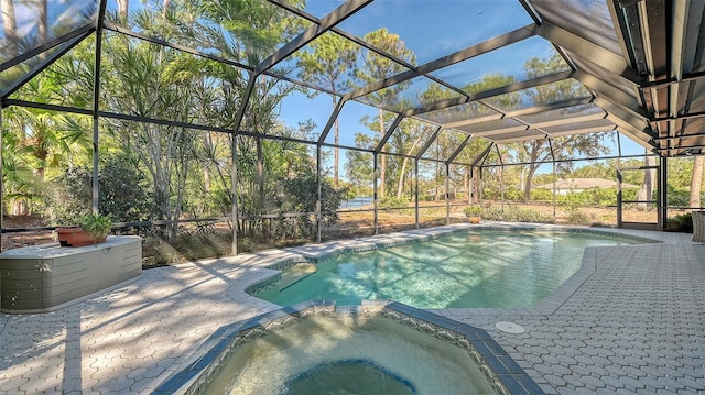 view of swimming pool with a lanai, a patio area, and an in ground hot tub