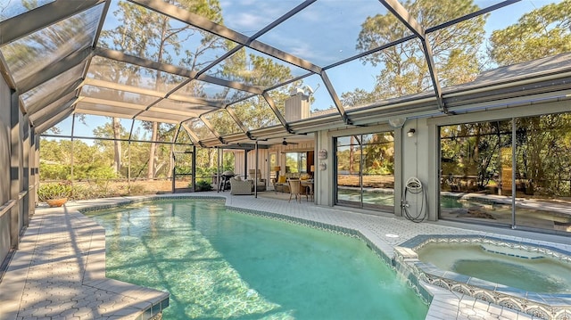 view of swimming pool featuring a lanai, ceiling fan, a patio area, and an in ground hot tub