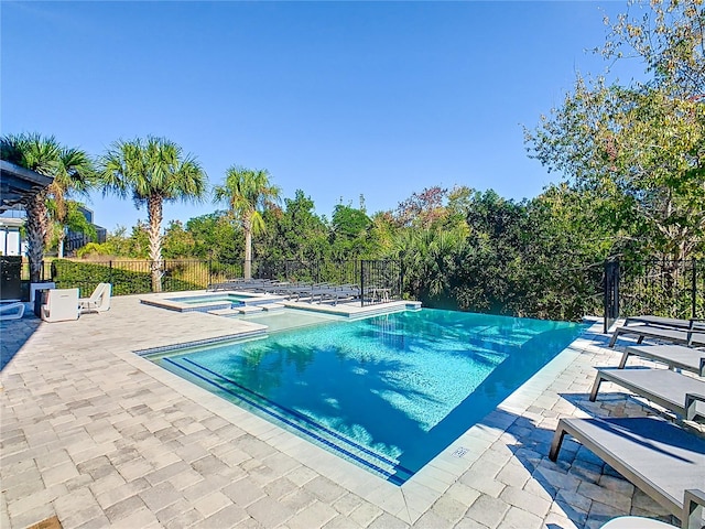 view of swimming pool with an in ground hot tub and a patio area