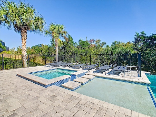 view of pool featuring an in ground hot tub and a patio area