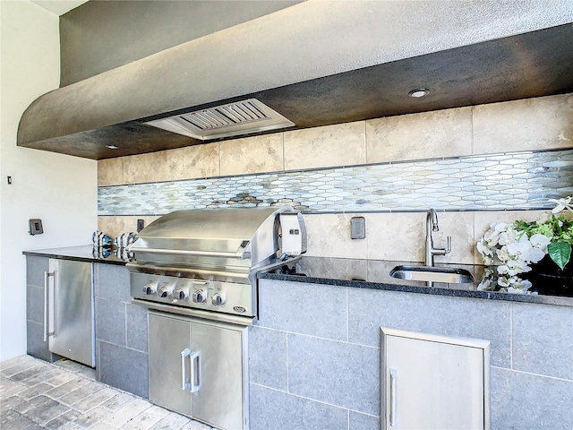 kitchen with tasteful backsplash, stainless steel refrigerator, sink, and light hardwood / wood-style flooring