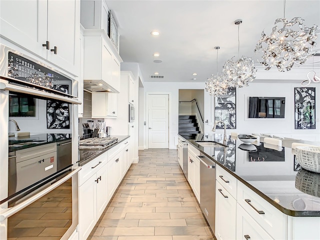 kitchen with white cabinets, pendant lighting, stainless steel appliances, and sink