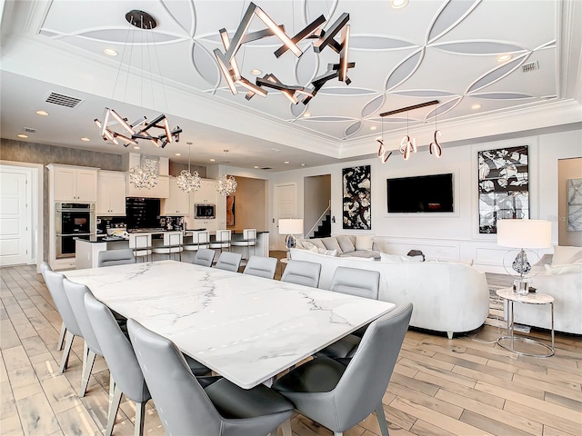 dining space with crown molding, light hardwood / wood-style flooring, and a chandelier