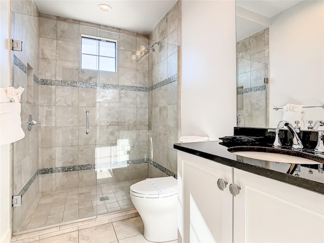 bathroom with tile patterned floors, vanity, toilet, and an enclosed shower