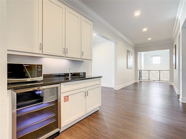 kitchen featuring wine cooler, crown molding, dark hardwood / wood-style flooring, and white cabinets