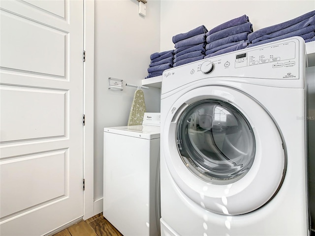 washroom featuring washing machine and dryer and dark hardwood / wood-style flooring