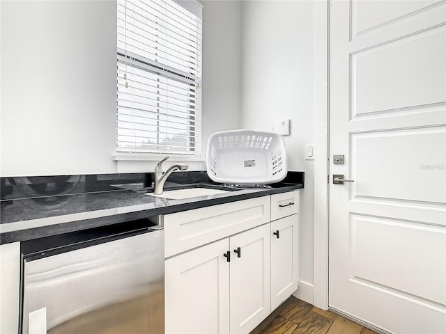 kitchen with stainless steel dishwasher, dark hardwood / wood-style flooring, white cabinetry, and sink