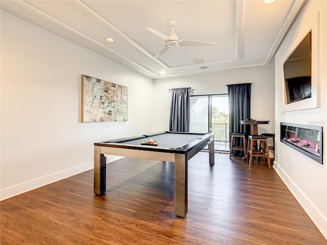 recreation room with a tray ceiling, ceiling fan, dark wood-type flooring, and pool table