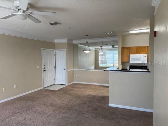 kitchen with kitchen peninsula, ornamental molding, ceiling fan, decorative light fixtures, and carpet floors