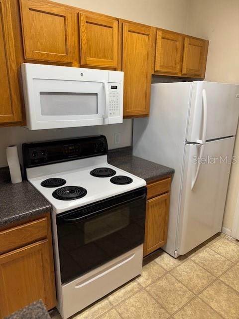 kitchen with light tile patterned flooring and white appliances