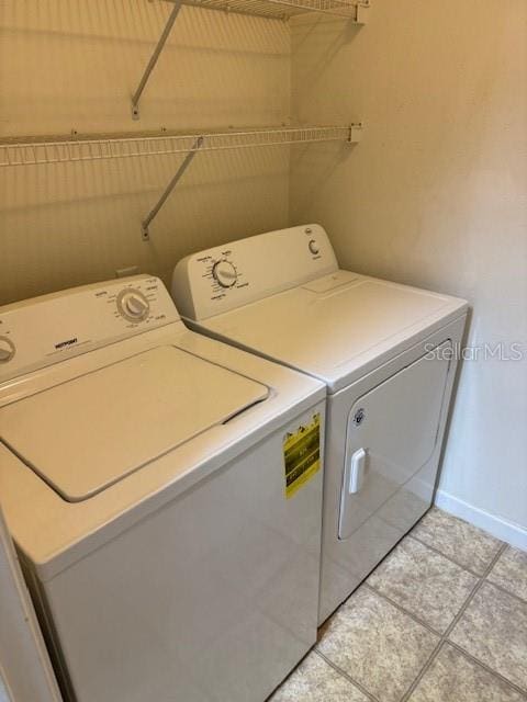 laundry area featuring washing machine and dryer and light tile patterned flooring