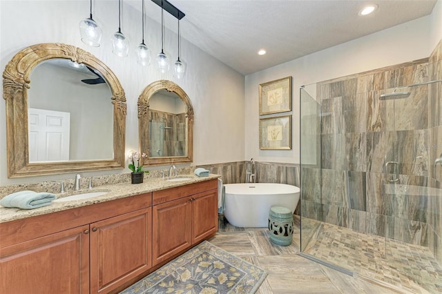 bathroom featuring tile patterned flooring, a textured ceiling, vanity, independent shower and bath, and tile walls