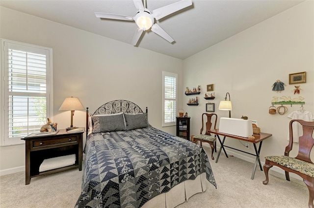 bedroom featuring ceiling fan, light colored carpet, and multiple windows