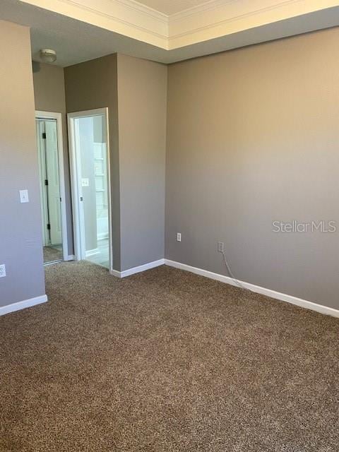 carpeted spare room featuring crown molding