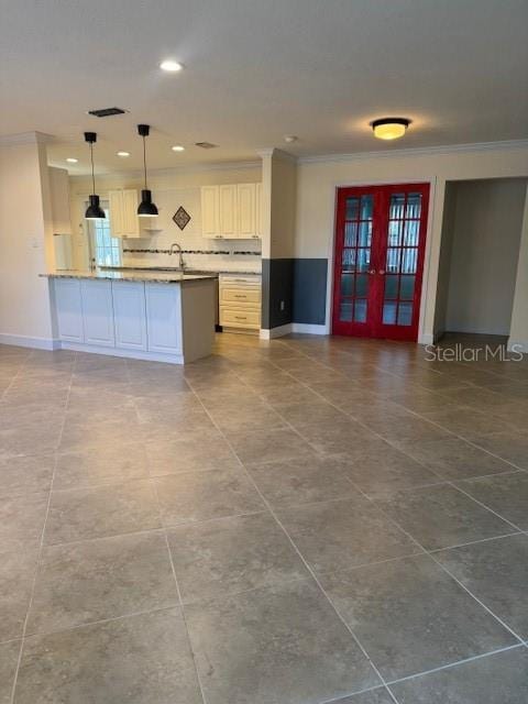 kitchen with french doors, backsplash, ornamental molding, decorative light fixtures, and white cabinetry