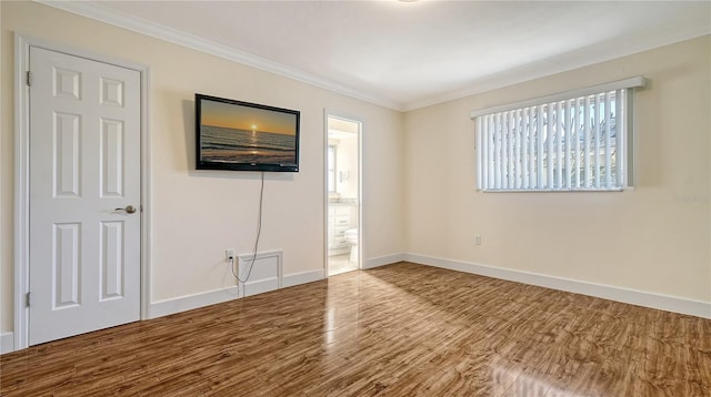 empty room with crown molding and hardwood / wood-style floors