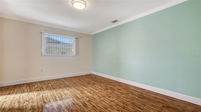 spare room with wood-type flooring and ornamental molding