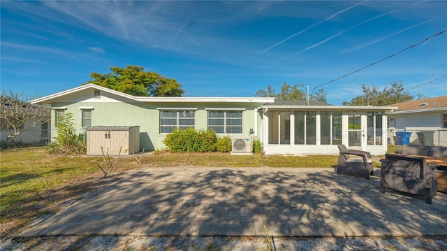 rear view of property featuring a sunroom, ac unit, a patio, and a lawn