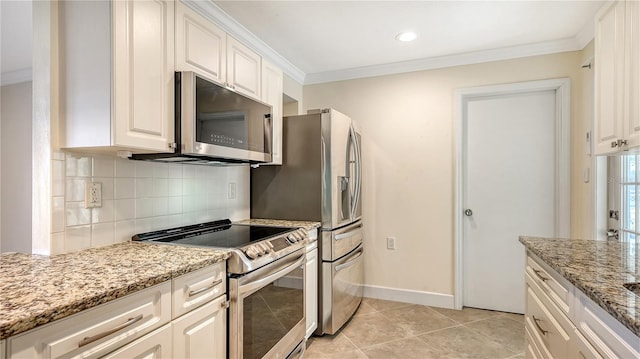 kitchen featuring light stone counters, appliances with stainless steel finishes, and white cabinetry